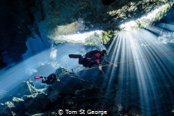 Diving through magnificent sunbeams in the cenotes of Mex... by Tom St George 